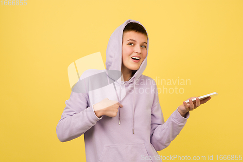 Image of Caucasian girl\'s portrait isolated on yellow studio background with copyspace