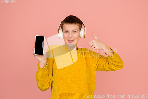 Image of Caucasian girl\'s portrait isolated on coral pink studio background with copyspace