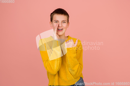 Image of Caucasian girl\'s portrait isolated on coral pink studio background with copyspace