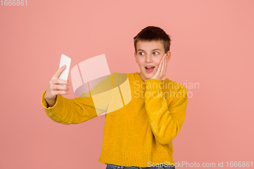 Image of Caucasian girl\'s portrait isolated on coral pink studio background with copyspace