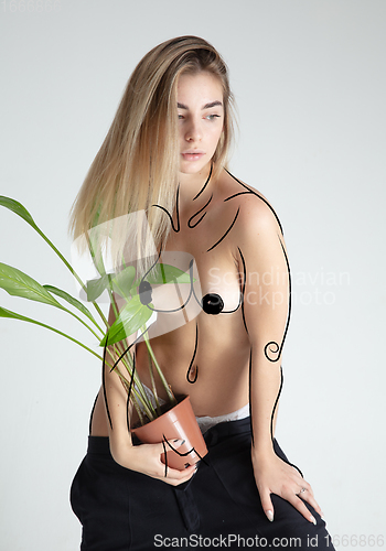 Image of Young blonde beautiful naked woman with line art drawing illustration on body