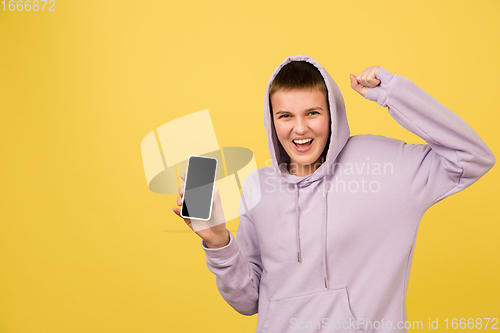 Image of Caucasian girl\'s portrait isolated on yellow studio background with copyspace