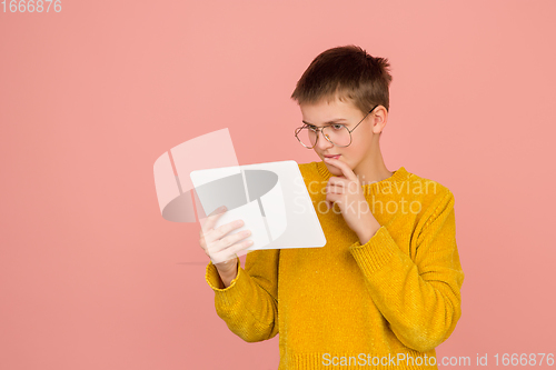 Image of Caucasian girl\'s portrait isolated on coral pink studio background with copyspace