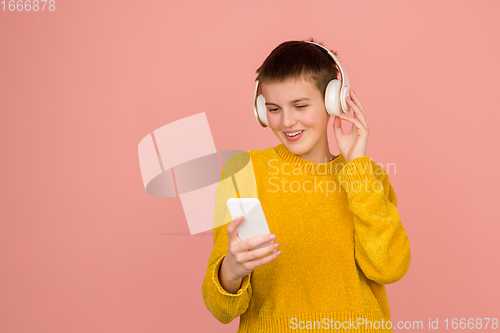 Image of Caucasian girl\'s portrait isolated on coral pink studio background with copyspace