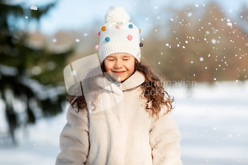 Image of happy little girl in winter clothes outdoors