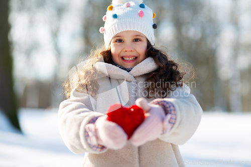 Image of happy little girl with heart outdoors in winter