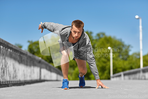 Image of young man running across city bridge