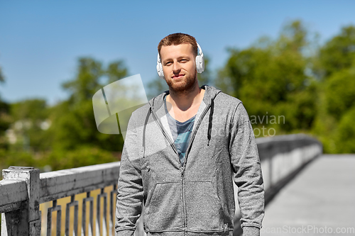 Image of man in headphones listening to music outdoors