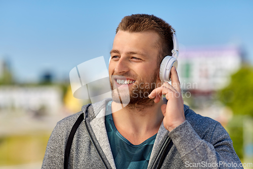 Image of man in headphones listening to music outdoors