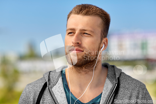 Image of man in earphones listening to music outdoors