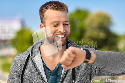 Image of happy man with fitness tracker in city