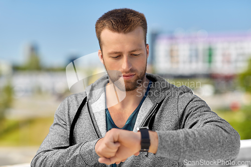 Image of man with fitness tracker in city