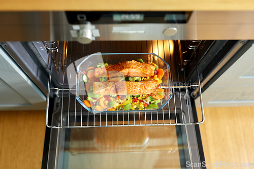 Image of food cooking in baking dish in oven at home