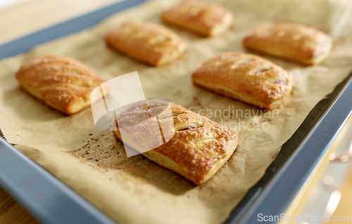 Image of baking tray with jam pies at home kitchen