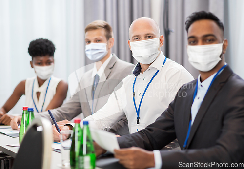 Image of business people in masks at meeting or conference