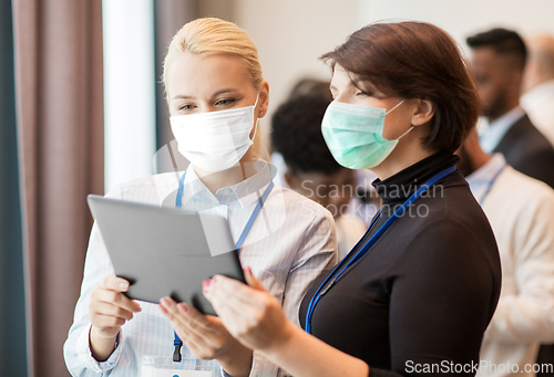 Image of business people in masks with tablet computer