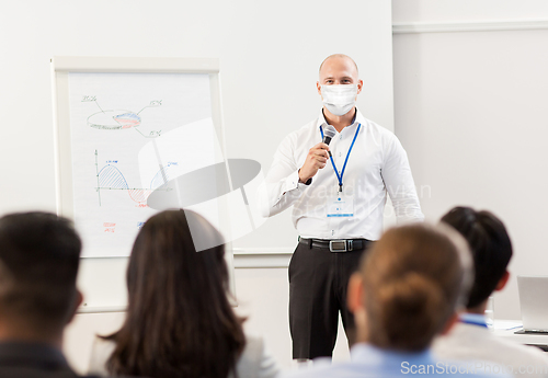 Image of businessman in mask at business conference