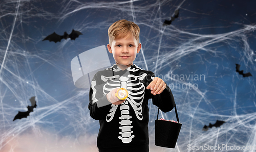 Image of boy with candies and flashlight on halloween