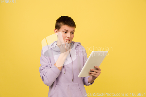 Image of Caucasian girl\'s portrait isolated on yellow studio background with copyspace