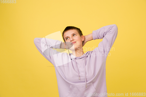 Image of Caucasian girl\'s portrait isolated on yellow studio background with copyspace