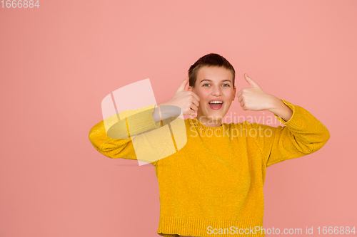 Image of Caucasian girl\'s portrait isolated on coral pink studio background with copyspace