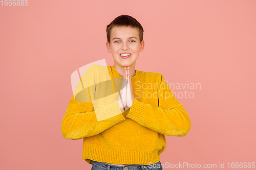 Image of Caucasian girl\'s portrait isolated on coral pink studio background with copyspace
