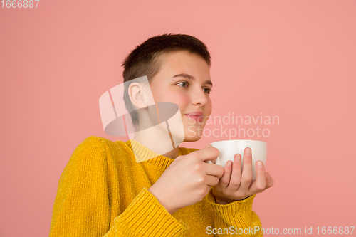 Image of Caucasian girl\'s portrait isolated on coral pink studio background with copyspace
