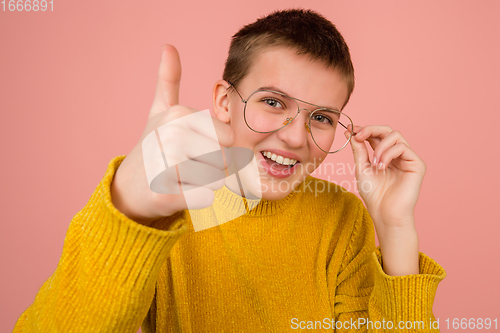 Image of Caucasian girl\'s portrait isolated on coral pink studio background with copyspace