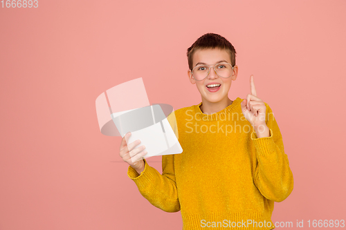 Image of Caucasian girl\'s portrait isolated on coral pink studio background with copyspace