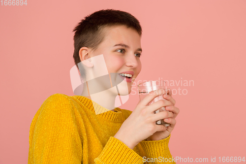 Image of Caucasian girl\'s portrait isolated on coral pink studio background with copyspace