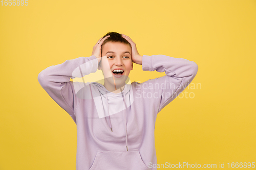 Image of Caucasian girl\'s portrait isolated on yellow studio background with copyspace