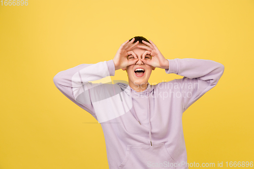 Image of Caucasian girl\'s portrait isolated on yellow studio background with copyspace