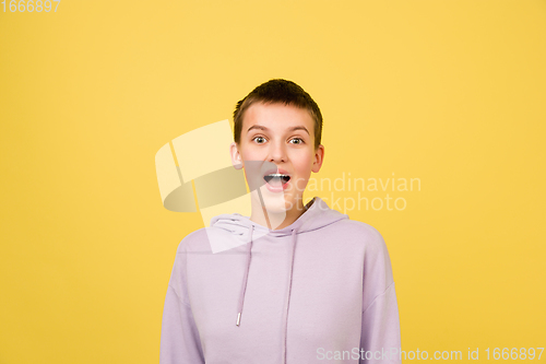 Image of Caucasian girl\'s portrait isolated on yellow studio background with copyspace