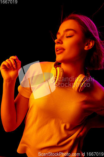 Image of Caucasian woman\'s portrait isolated on black studio background in multicolored neon light