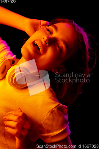 Image of Caucasian woman\'s portrait isolated on black studio background in multicolored neon light