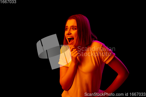 Image of Caucasian woman\'s portrait isolated on black studio background in multicolored neon light