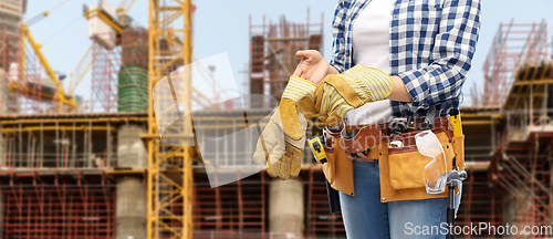 Image of woman or builder with gloves and working tools