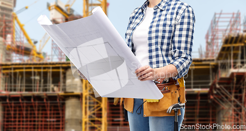 Image of female builder with blueprint and working tools