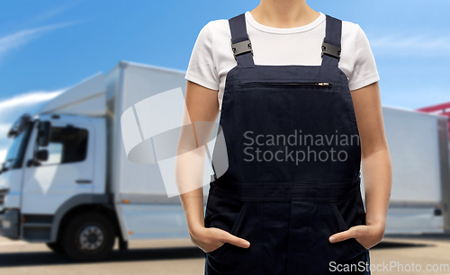 Image of close up of female worker in overall over truck