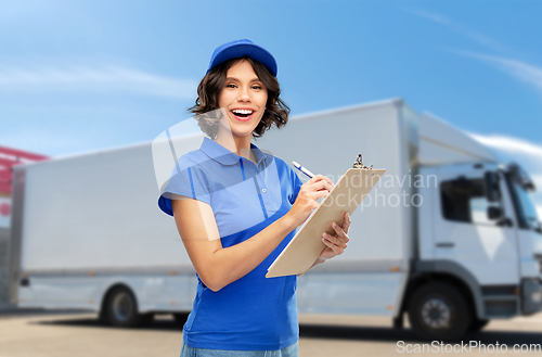 Image of happy delivery girl with clipboard and pen writing