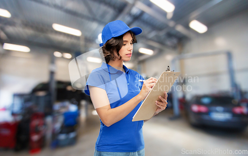 Image of female worker with clipboard at car service