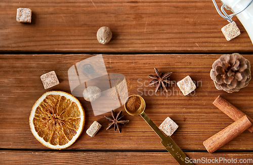 Image of spices, brown sugar and milk on wooden background