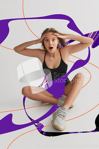 Image of Stylish young girl\'s portrait on white studio background with bright illustrated lines of fluid neoned colors. Having fun, happy, full length