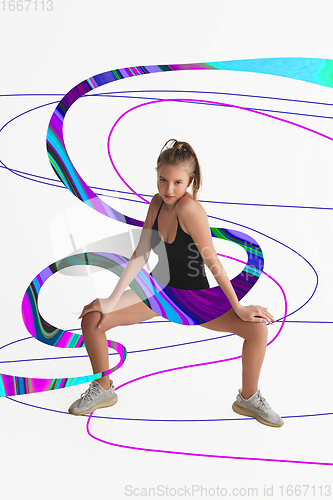 Image of Stylish young girl\'s portrait on white studio background with bright illustrated lines of fluid neoned colors. Having fun, happy, full length