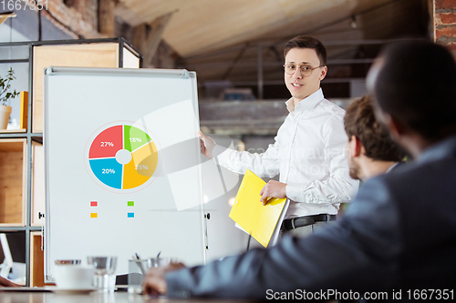 Image of Diverse group of co-workers having casual discussion in office. Executives during friendly discussion, month reporting, creative meeting