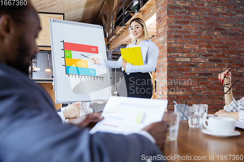 Image of Diverse group of co-workers having casual discussion in office. Executives during friendly discussion, month reporting, creative meeting