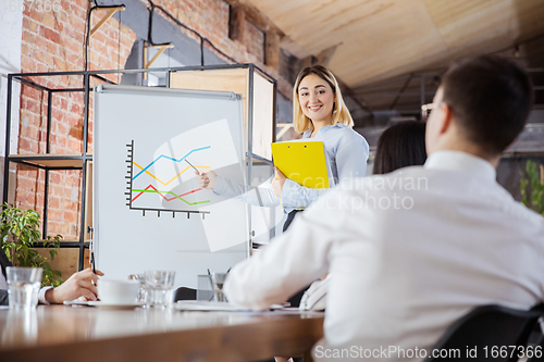 Image of Diverse group of co-workers having casual discussion in office. Executives during friendly discussion, month reporting, creative meeting