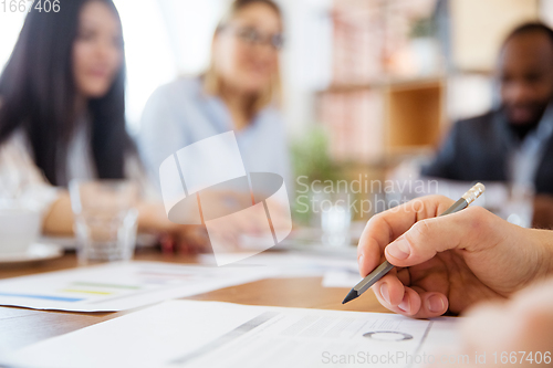 Image of Close up hands of co-workers having casual discussion in office. Executives during friendly discussion, month reporting, creative meeting