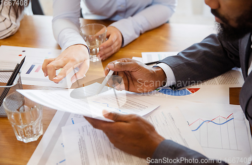 Image of Close up hands of co-workers having casual discussion in office. Executives during friendly discussion, month reporting, creative meeting