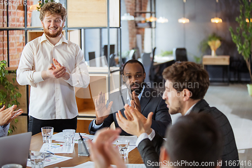 Image of Diverse group of co-workers having casual discussion in office. Executives during friendly discussion, month reporting, creative meeting